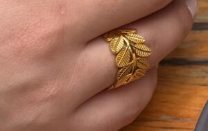 Anillo de hojas de acero inoxidable dorado con diseño botánico y calado detallado joyería Cianna