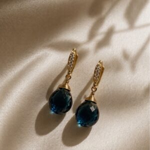 Aretes colgantes con piedra natural London Blue facetada y detalle de microzirconias en chapa de oro 22k marca Cianna