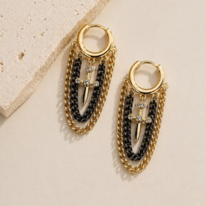 Arracadas tipo huggie con cadenas colgantes en oro y gun metal con dije de daga y microzirconias marca Cianna