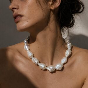 Modelo luciendo collar de perlas barrocas naturales gigantes con matices tornasol marca Cianna