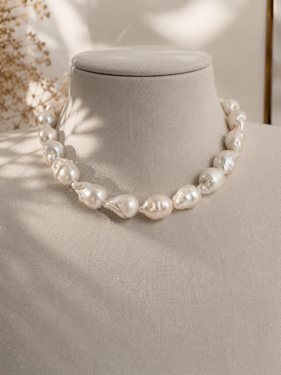 Modelo luciendo collar de perlas barrocas naturales gigantes con matices tornasol marca Cianna