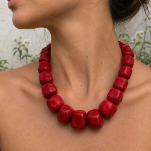 Primer plano de collar chunky de coral natural rojo sobre la piel estilo editorial